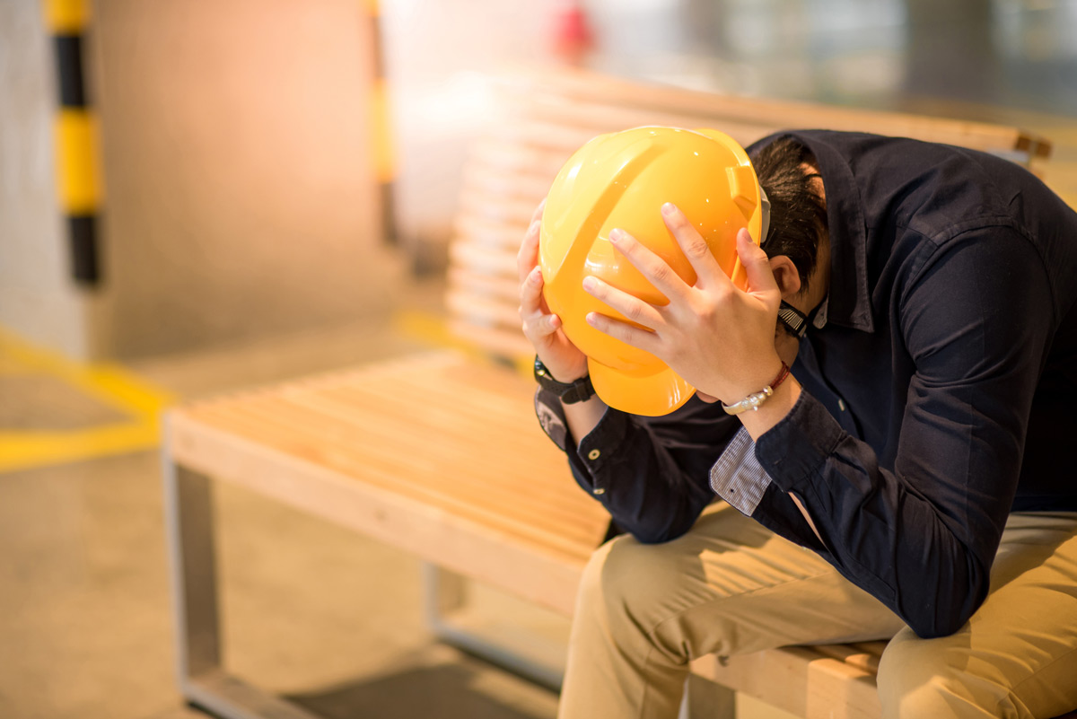 Construction worker with head in hands